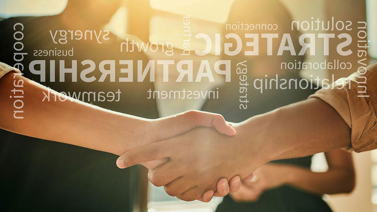 A close up of two people shaking hands with words like strategic, growth, and partnership overlaid in light text on the image